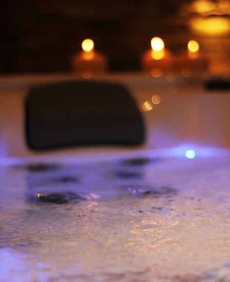 Foto Badewanne mit Schaum im Wasser und Kerzen, stimmungsvoll